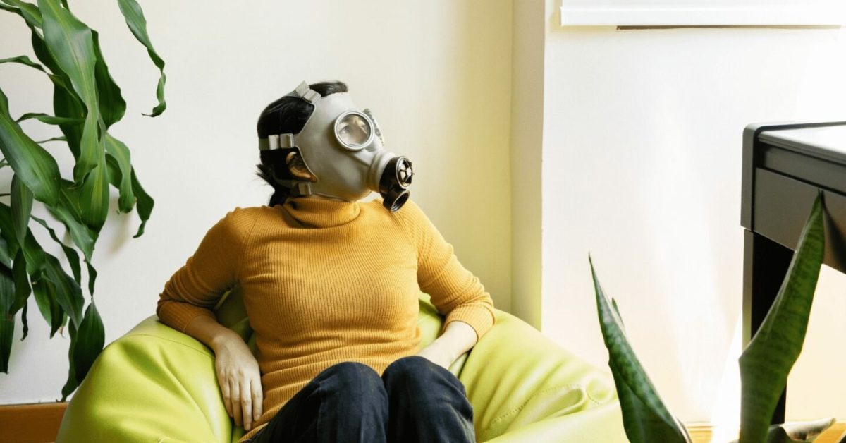 women with gas mask sitting in bean bag chair