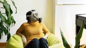 women with gas mask sitting in bean bag chair