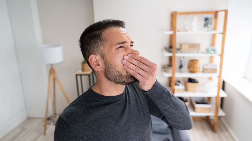 A man holds his nose against the smell coming from his air ducts