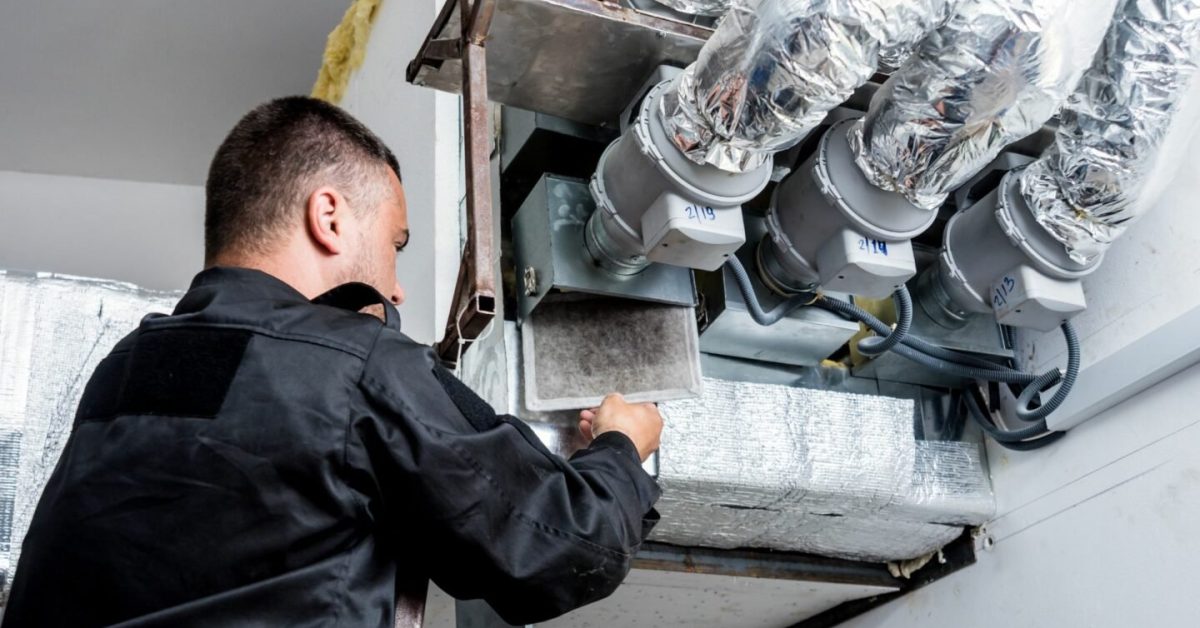 An expert in HVAC dampers works on a commercial system