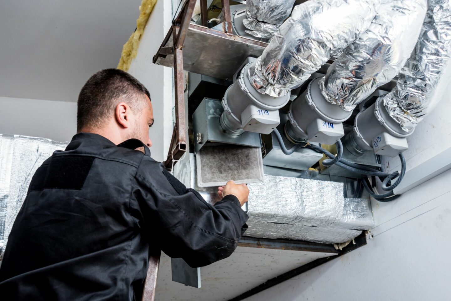 An expert in HVAC dampers works on a commercial system