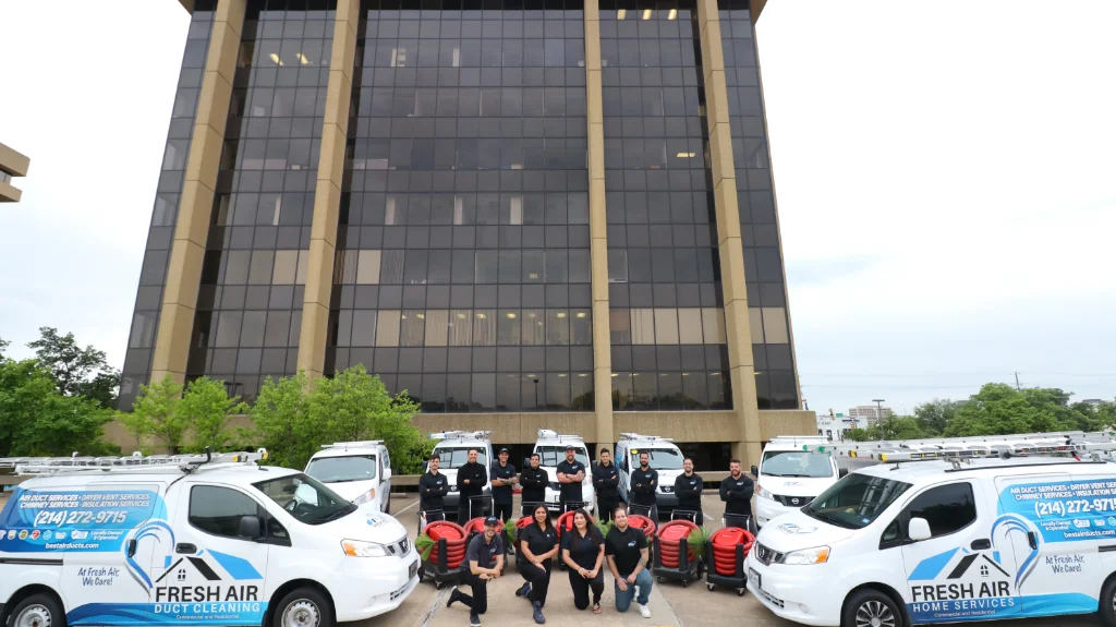Fresh Air Home Services team posing with service vans and equipment in front of office building.